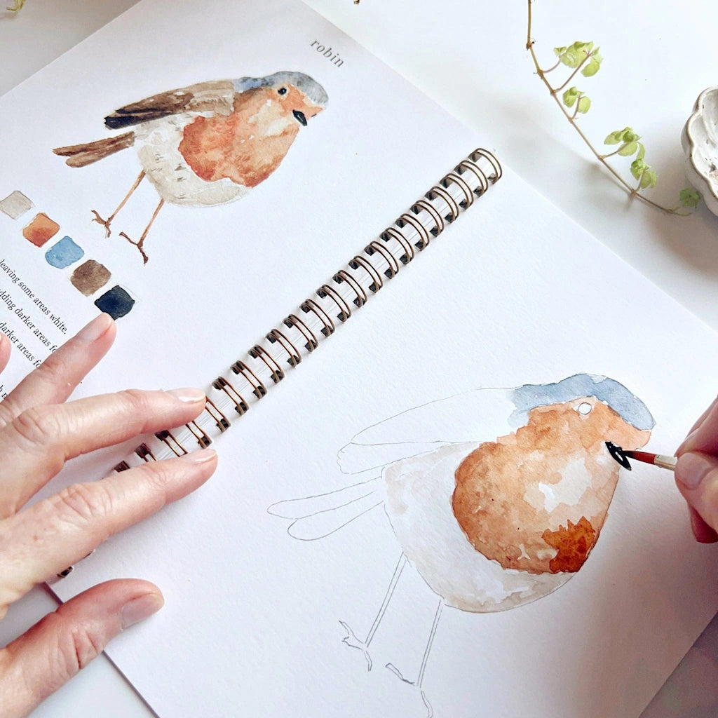 The Birds Watercolor Workbook includes 12 bird illustrations with an example of the finished painting, step-by-step instructions, and a lightly illustrated sketch for you to paint. Available from Seattle florist and gift basket company, Campanula Design Studio in the Magnolia neighborhood.