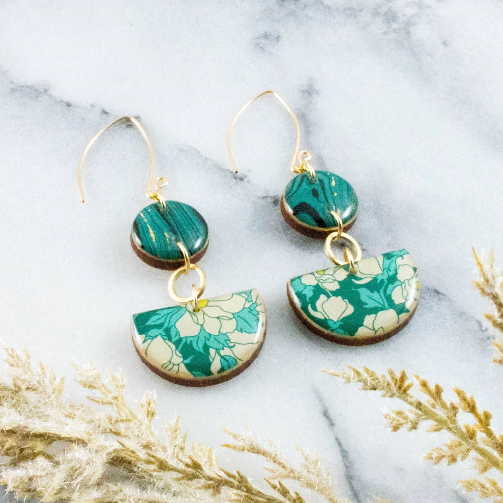 Teal Dogwood Floral Half Circle Stacked Earrings are a classic and versatile option in statement earrings. These earrings feature a dogwood floral pattern in rich teal and coordinating teal and gold marbled paper, with raw brass accent circles. Available from Campanula Design Studio, Seattle florist and gift basket shop. 