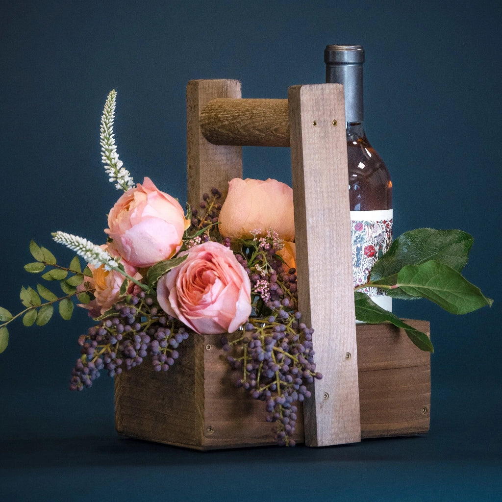 Campanula Design's handcrafted wooden wine caddy perfectly holds a designer's choice bud vase of flowers and a bottle of wine. Custom add-ons available.