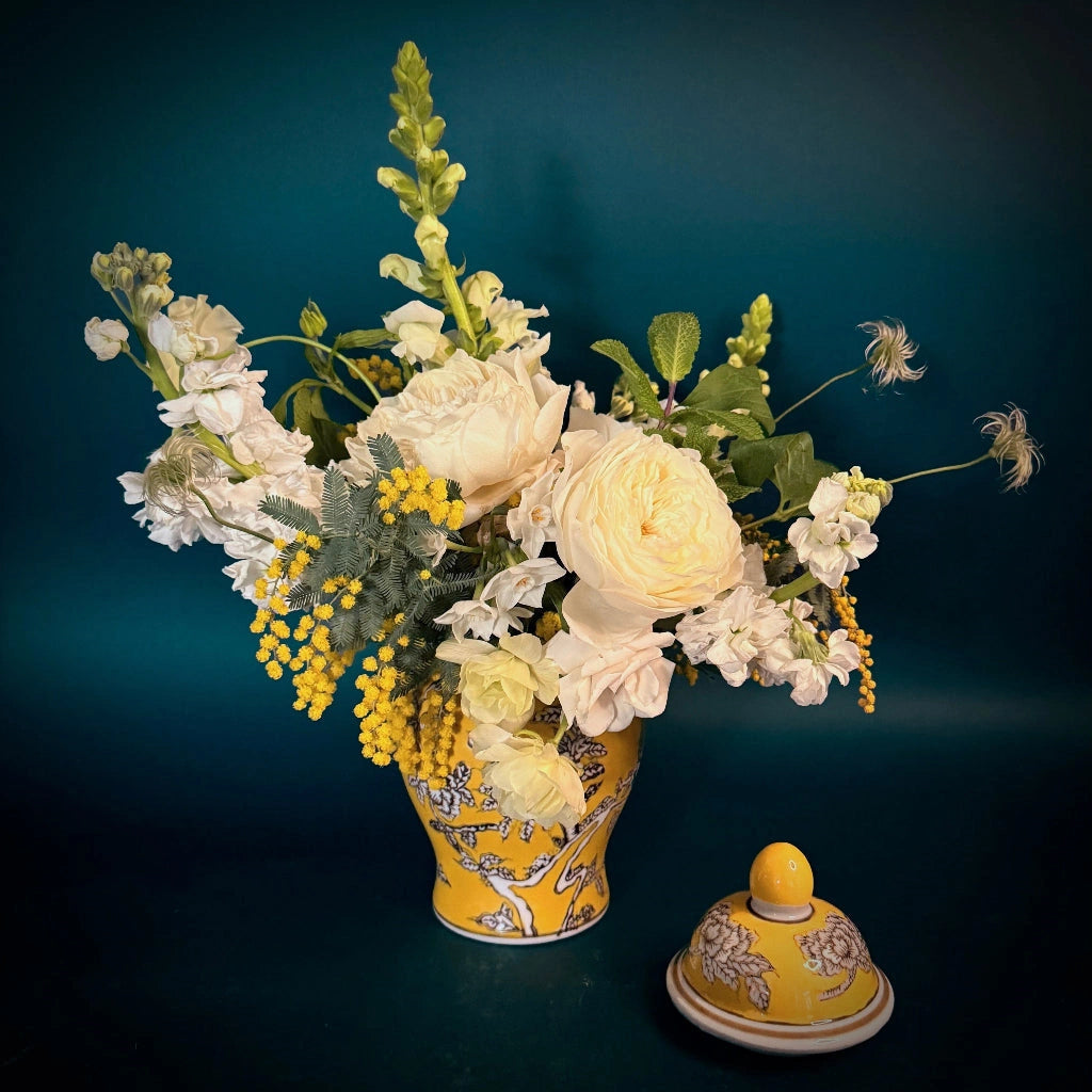 A beautiful arrangement of creamy whites and soft yellows designed in a vibrant ginger jar. 