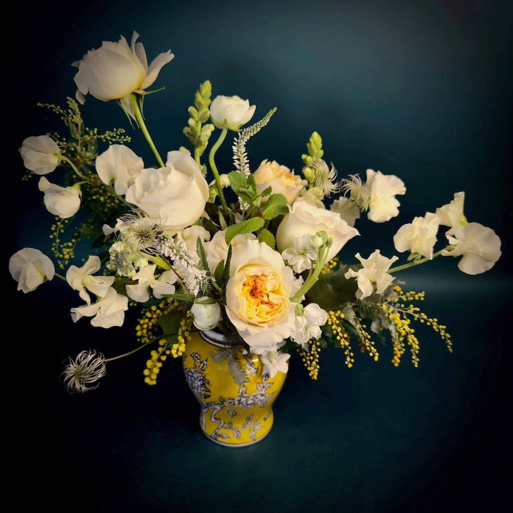 A beautiful arrangement of creamy whites and soft yellows designed in a vibrant ginger jar. 