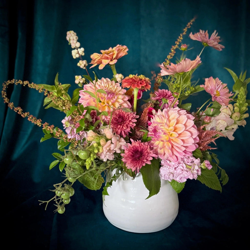 A mix of seasonal blooms designed in a ceramic vase. 