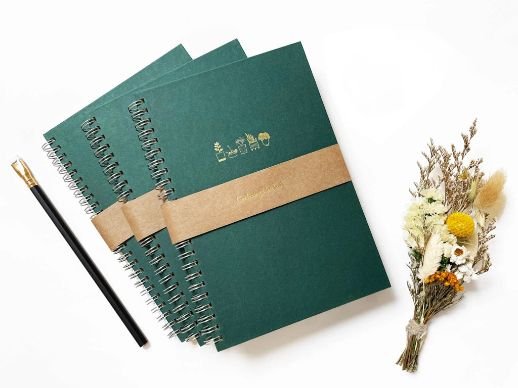 Keep your gardening notes organized in style with these tidy, handy spiral-bound notebooks, foil pressed in gold with a row of five sweet potted plants. Available from Campanula Design Studio, Seattle's premier gift shop and florist.