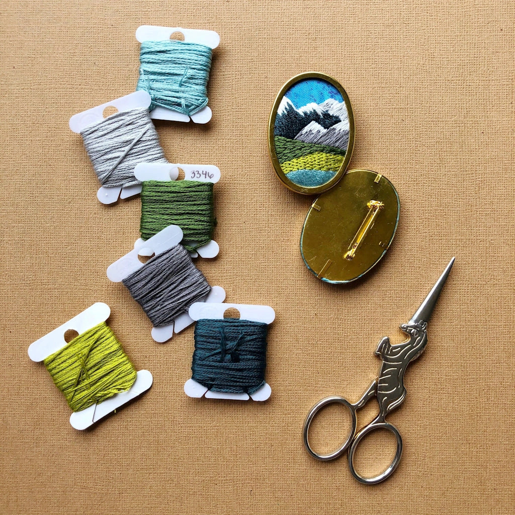 Give the gift of crafting to your crafty friend. This embroidery kit lets you create your own oval landscape pin. Available from Campanula Design Studio in Seattle.