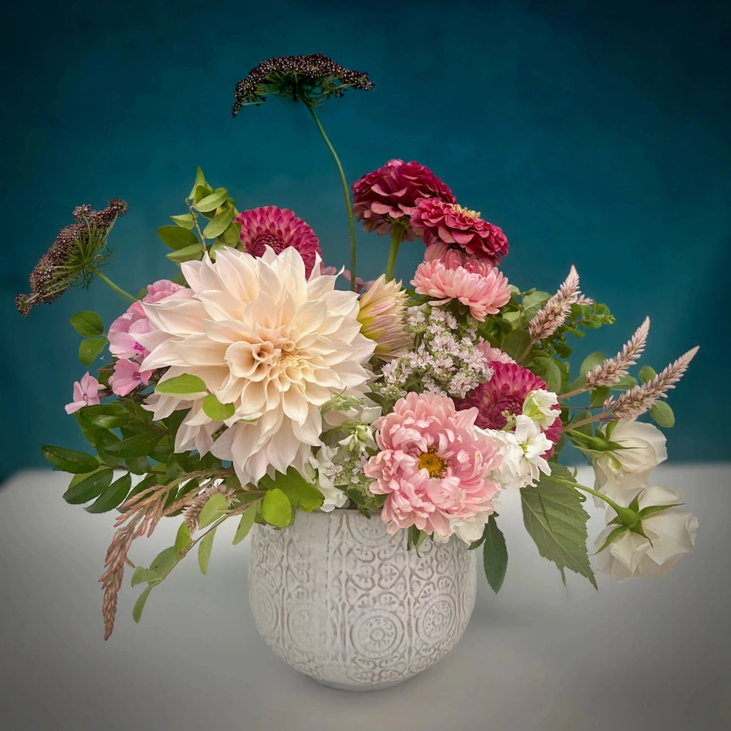 Campanula's "Raspberry Sorbet" flower arrangement features a delightful palette of pale blush, soft pink, and deeper tones in a ceramic vase.