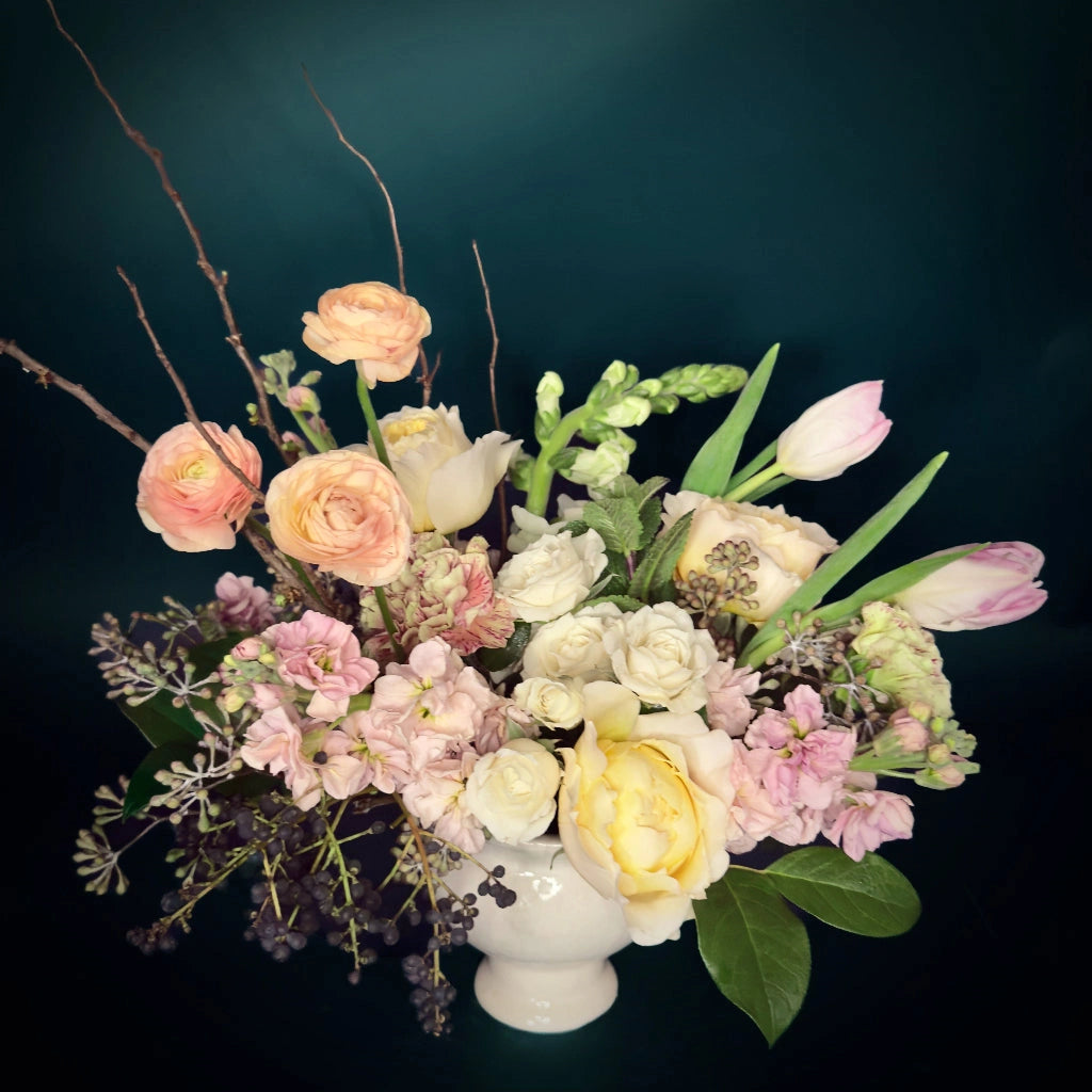 The Serenity floral arrangement from Campanula Design features a soft and soothing palette of pale pink, peach, white, and lush greens designed in a simple vase.