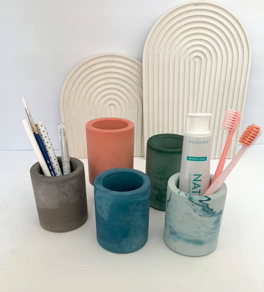 Multipurpose, handmade concrete cylindrical vessel can be used for toothbrushes, pens/pencils, coffee stir sticks, makeup brushes, air plants, small flowers, and much more! 
Available from Campanula Design Studio, Seattle's Gift Basket solution store.