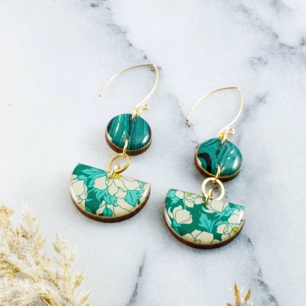 Teal Dogwood Floral Half Circle Stacked Earrings are a classic and versatile option in statement earrings. These earrings feature a dogwood floral pattern in rich teal and coordinating teal and gold marbled paper, with raw brass accent circles. Available from Campanula Design Studio, Seattle florist and gift basket shop. 